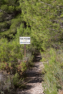 Photographie d'un petit chemin pédestre vers Baux-de-Provence avec un panneau Danger