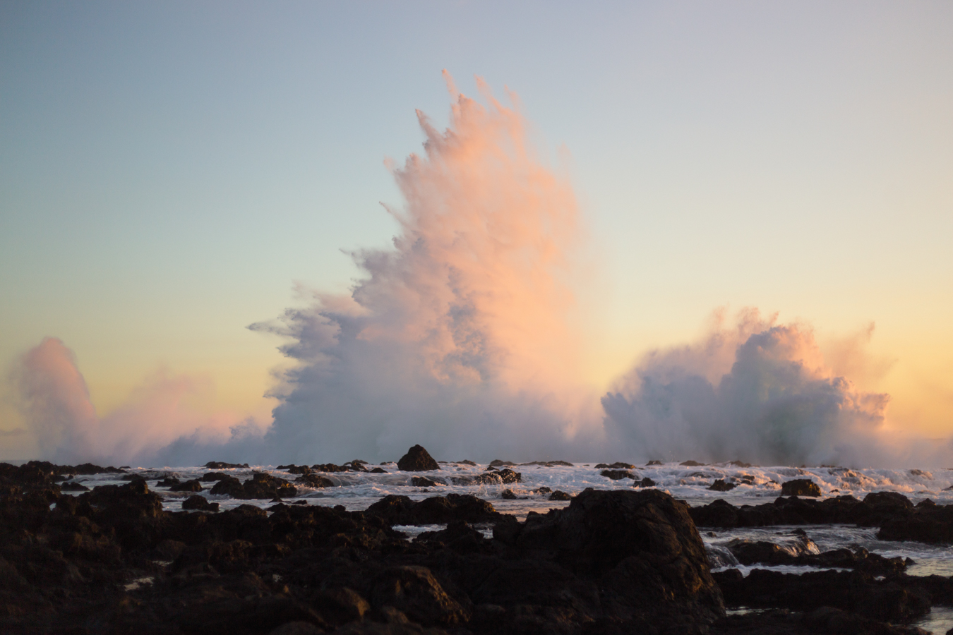 Mur d'eau d'une quinzaine de mètre provoquée par une vague se fracassant contre des rochers à la Réunion vers Saint-Leu lors d'un couché de soleil